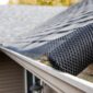 Gutter with mesh guard on a house roof 85x85