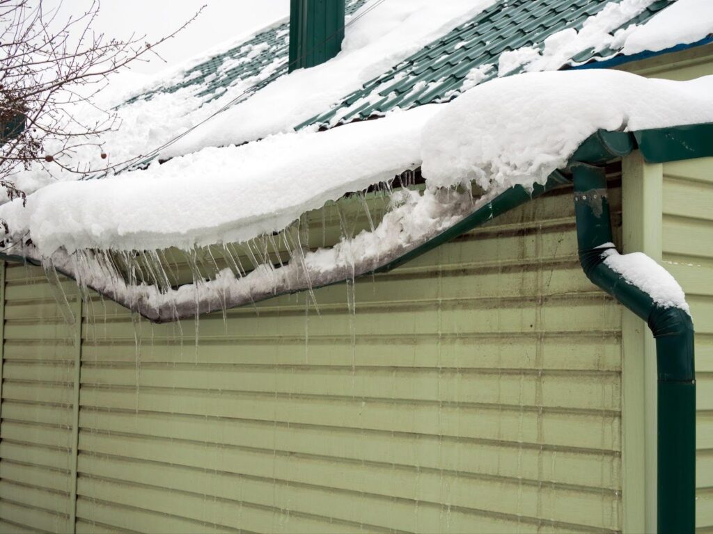 A gutter layered with fresh snow highlighting the effects of winter weather on urban infrastructure