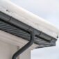 A house roof blanketed in snow with a visible gutter beneath indicating cold winter conditions 85x85