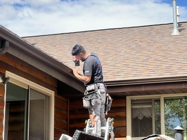 A man using a ladder to repair a roof focused on his task with tools nearby