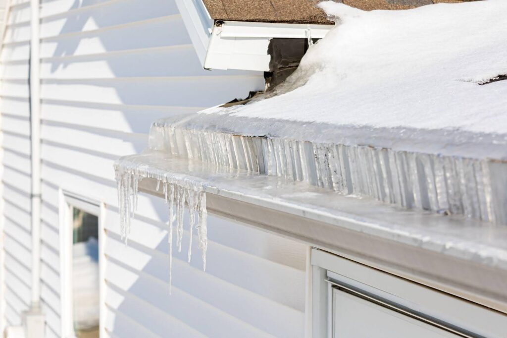 Ice forming in the gutter of a house reflecting sunlight and creating a wintery scene
